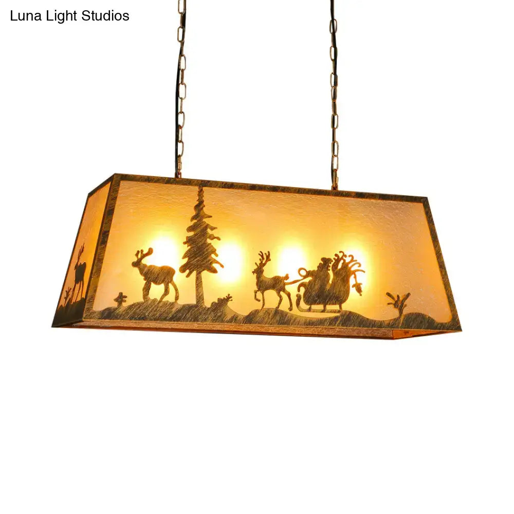 Rectangular etched linear island lamp with warm amber glass shade featuring carved reindeer santa and evergreen silhouettes