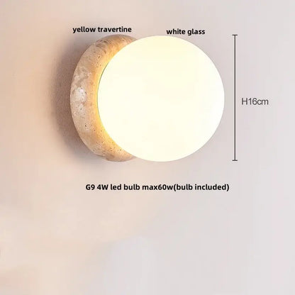 A modern wall light with a circular white glass diffuser on a rustic beige travertine base by decorbites led wall