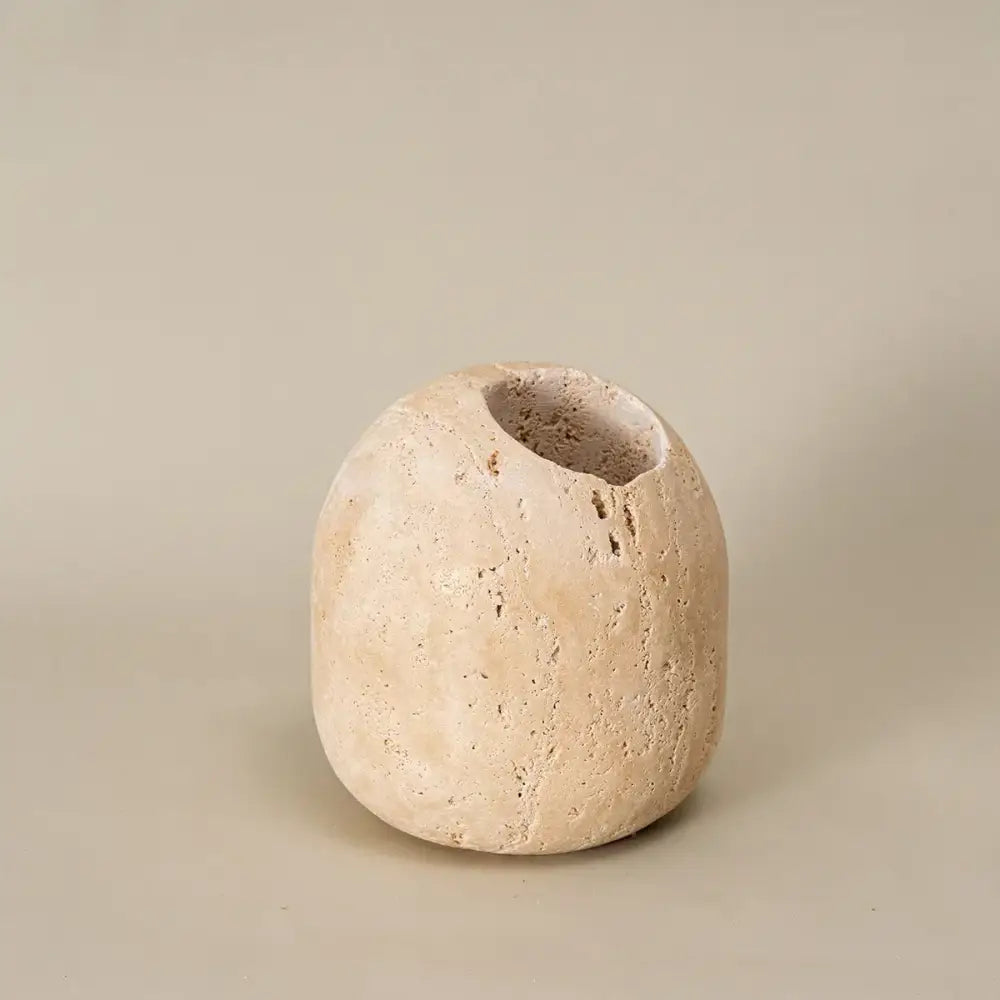 Beige travertine match holder with textured stone, rounded organic shape, and irregular opening for rustic living room decor