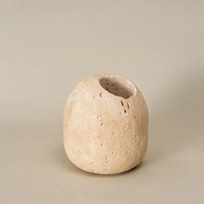 Beige travertine match holder with textured stone, rounded organic shape, and irregular opening for rustic living room decor