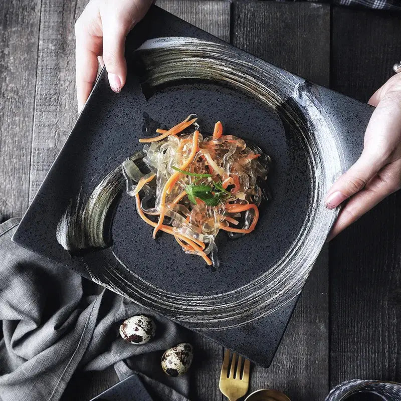 Rustic black ceramic sushi plate with textured brushstroke rim and speckled surface from decorbites black ceramic set