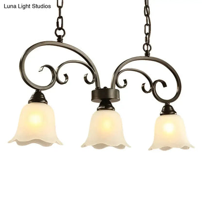 Black wrought iron DecorBites rustic pendant island lamp with black floral swirls and frosted white glass shades for restaurants