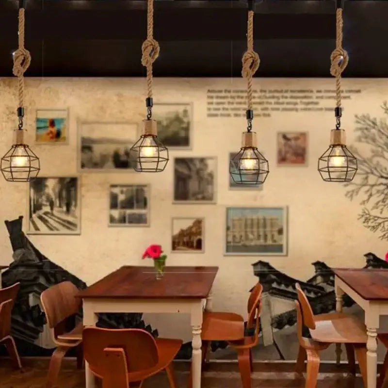 Rustic black iron pendant light with hemp rope cords and warm bulbs hanging in a dining room setting