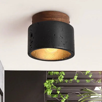 Rustic black travertine ceiling light with concrete texture and wooden top featuring warm gold interior for entrance hallway decor