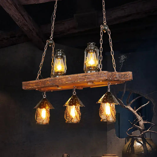 Rustic black wood lantern island ceiling light with three amber glass hanging lanterns and two suspended oil lamps