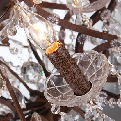 A clear glass candle-style bulb with warm glow in a rustic bronze decorbites crystal earth birdcage chandelier