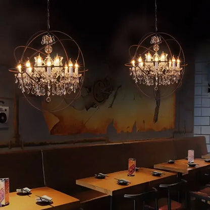 Two rustic bronze crystal earth birdcage chandeliers with spherical design and candle-style bulbs hang in dining room decorbites crystal earth