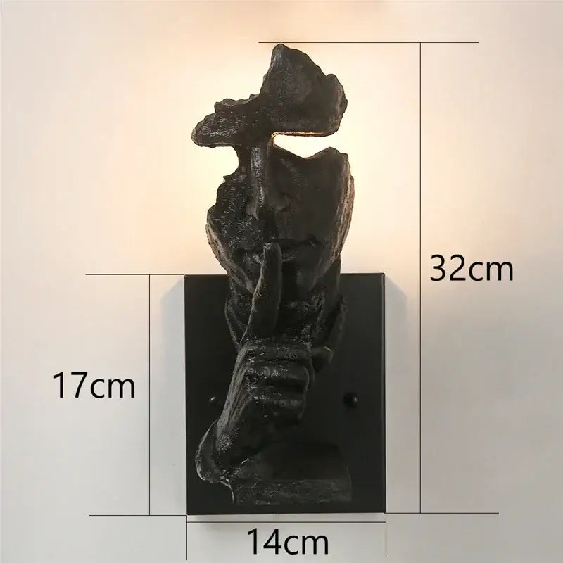 Black matte sculptural wall lamp shaped like a hand in shh gesture for decorbites loft face wall decor