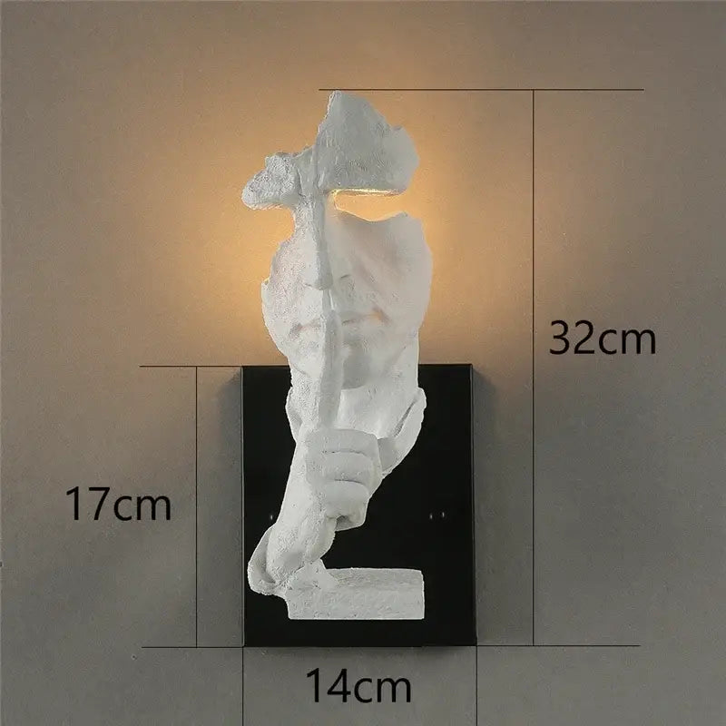 White sculptural wall lamp shaped like a figure holding an axe on black base decorbites loft face wall decor