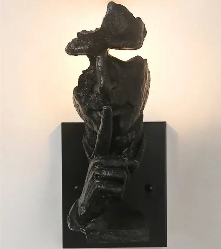 Black sculptural wall lamp shaped like a hand making shh gesture rustic bronze decorbites loft face wall lamp