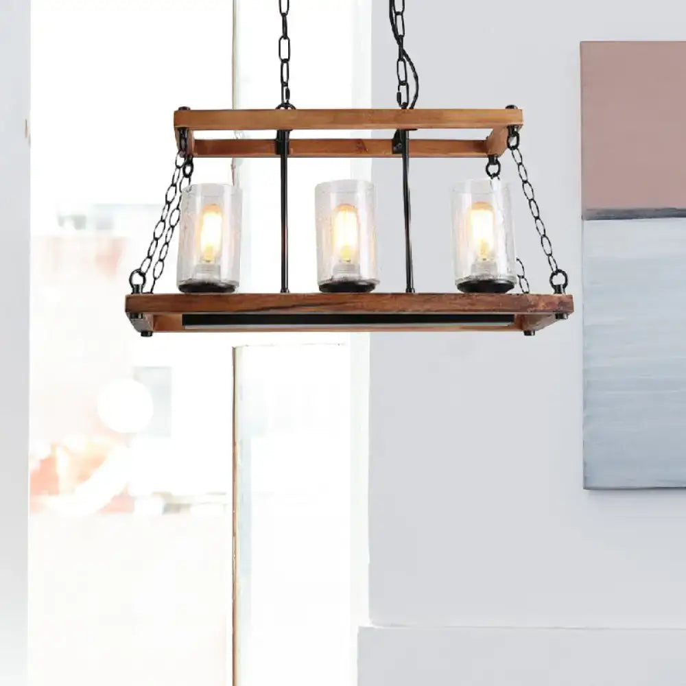 Rustic brown seed glass island light with wooden trapezoid guard and three clear candle bulbs on black metal chains