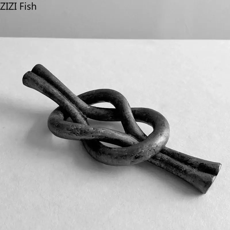 Rustic dark metal geometric knot resin sculpture with intertwined loops and textured finish for living room decorbites geometric knot