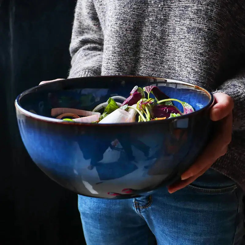 Rustic deep blue ceramic salad bowl with a glossy finish and wooden fork featuring ceramic porcelain design decorbites deep blue