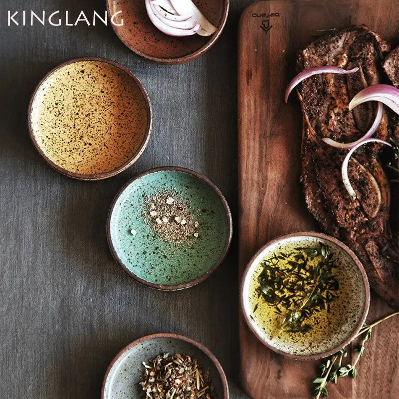 Set of four decorbites ceramic round sauce bowls in rustic earthy tones with speckled glazes holding seasonings