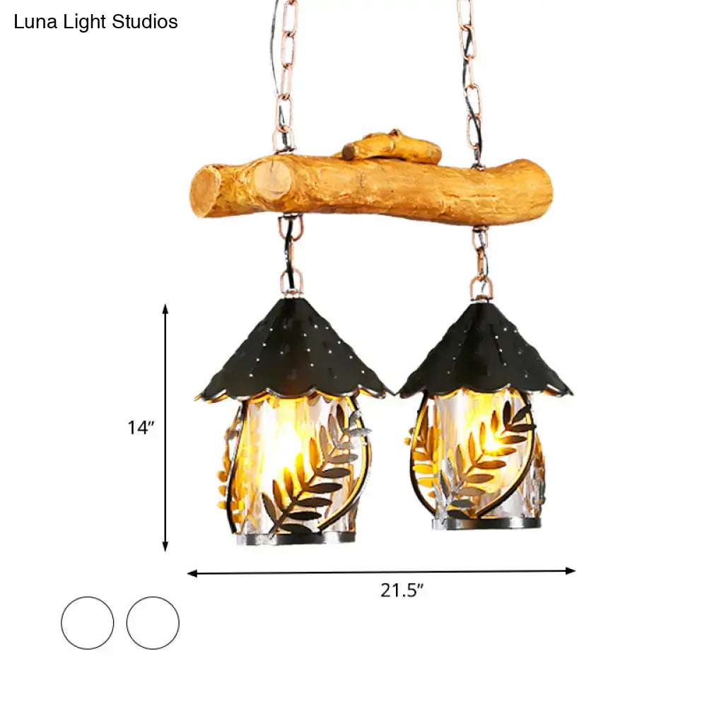 Rustic wooden branch pendant light with two glass lanterns featuring black metal roofs and fabric clear glass shade