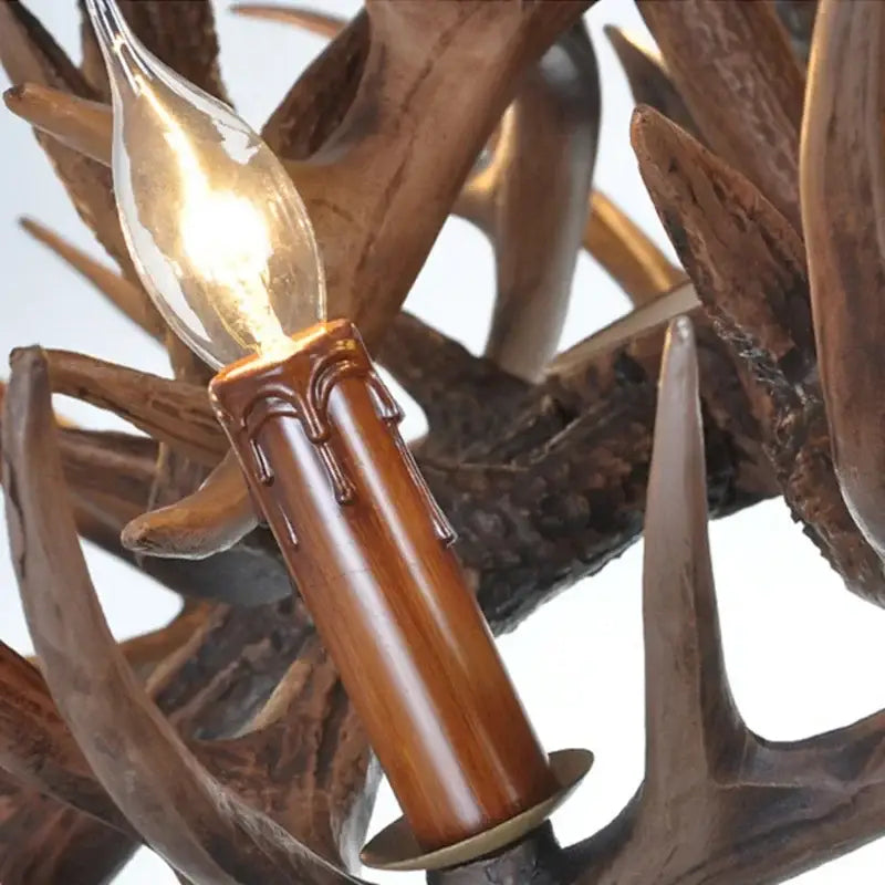 Rustic golden brown antler pendant chandelier dining room light with warm candle-style bulb and polished wooden base decorbites antler pendant