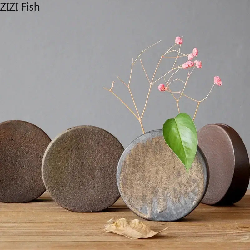 Rustic gray and brown coarse pottery vase small holding pink flowers and a green leaf for living room decorbites decor