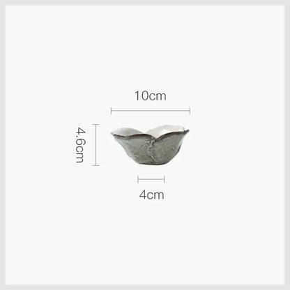 A delicate handcrafted rustic grayish white ceramic dish bowl set with soft gray glaze and textured ridges