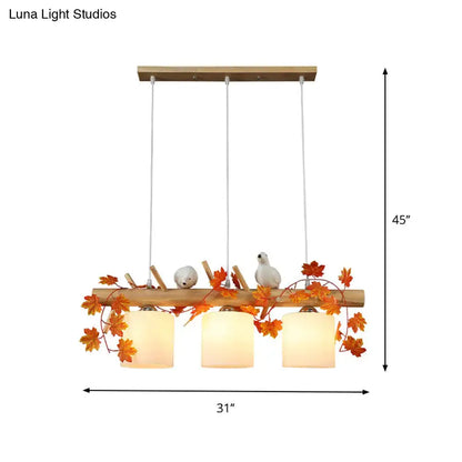 Rustic wooden pendant light with ivory glass shades featuring maple green leaf and bird décor for kitchen islands