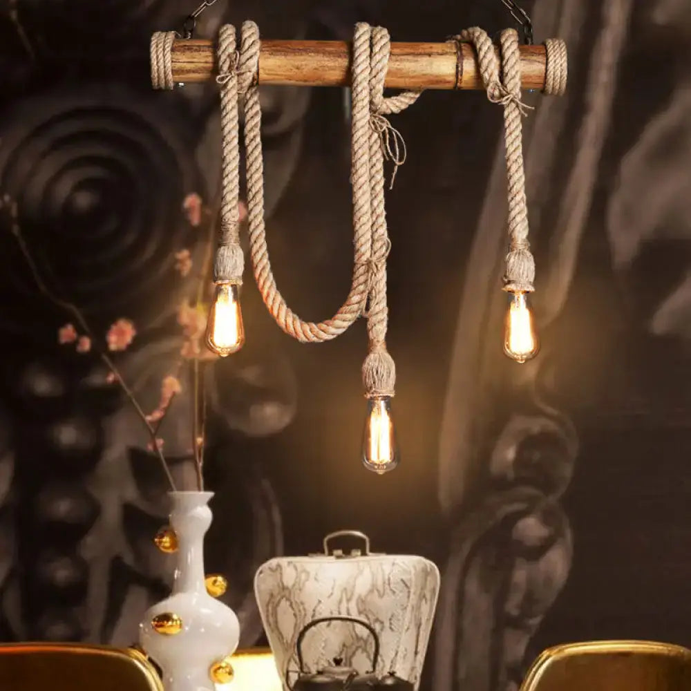 Rustic wooden beam island light with thick beige rope, bamboo accents, and three exposed filament bulbs by decorbites