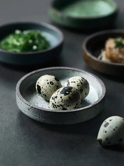Rustic speckled gray ceramic sauce dish holding three black-spotted quail eggs decorbites ceramic sauce dishes