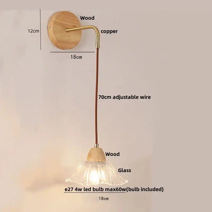 Rustic wood and brass wall light with clear glass bell shade and pull chain switch on natural wood circular backplate