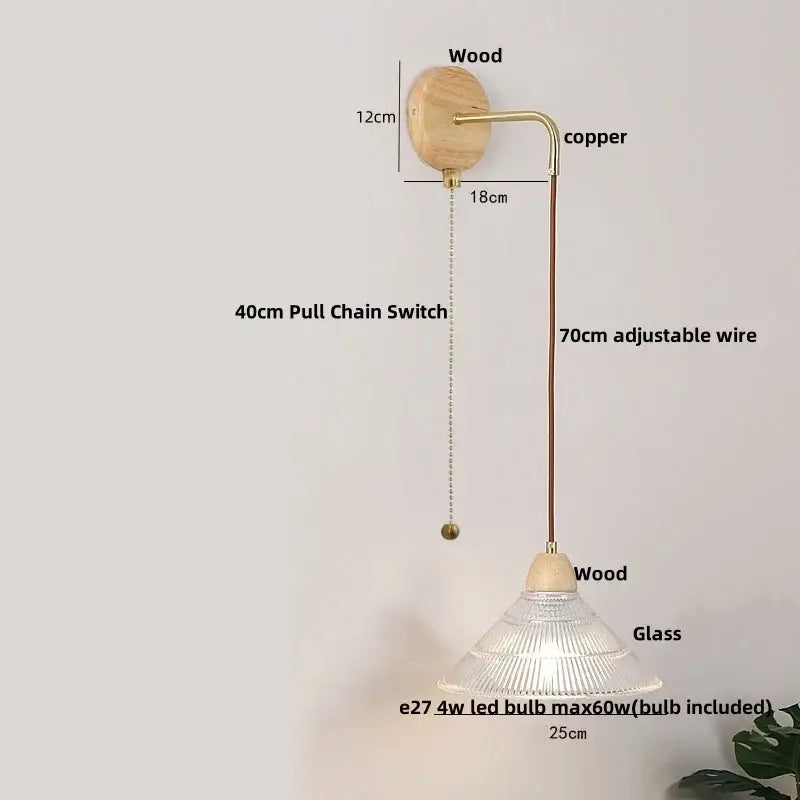 Rustic wood and brass wall light with pull chain switch featuring a natural wood base, copper arm, and clear glass shade
