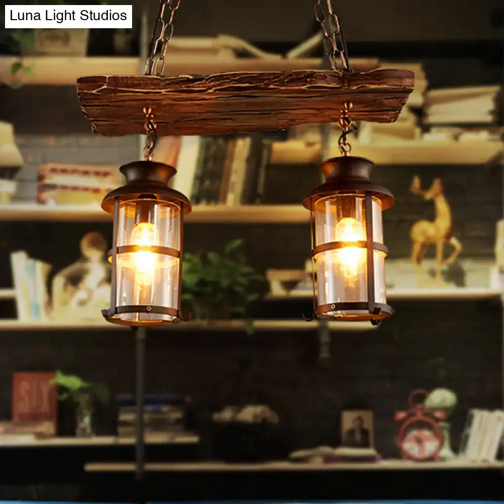 Rustic farmhouse brown pendant light with two clear glass vintage lanterns and brass accents for island lighting