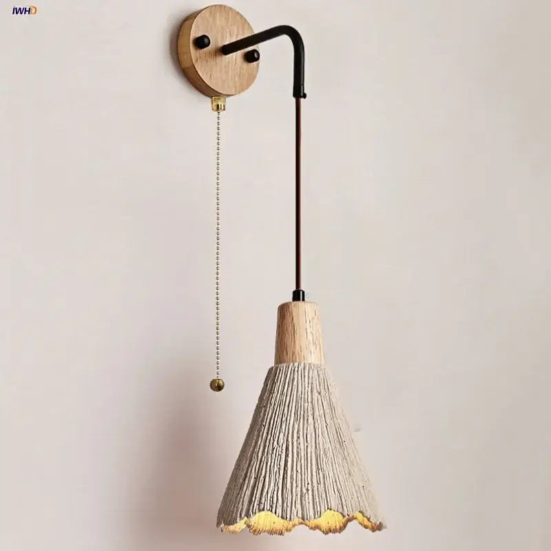Rustic wood wall light fixture with textured gray conical shade and gold trim featuring a pull chain for bedroom use