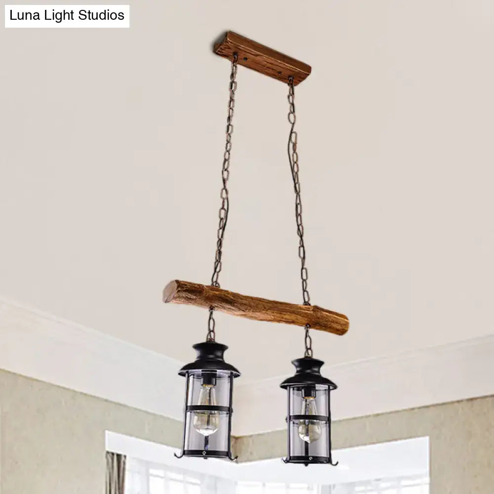 Rustic wooden beam pendant light with two black lanterns featuring clear glass and wood design for island lighting
