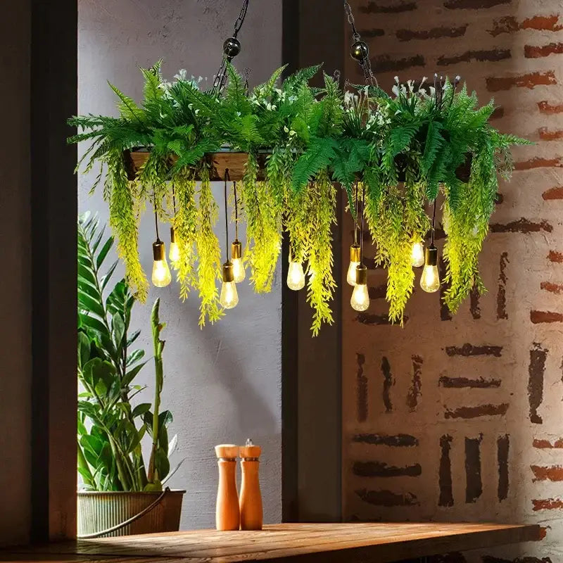 Rustic wood hanging chandeliers with lush green ferns yellow foliage and edison bulbs ideal for bar hanging chandeliers
