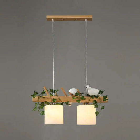 Decorbites modern wood linear island lighting with warm cylindrical shades and maple leaf plant accents on natural wood branch