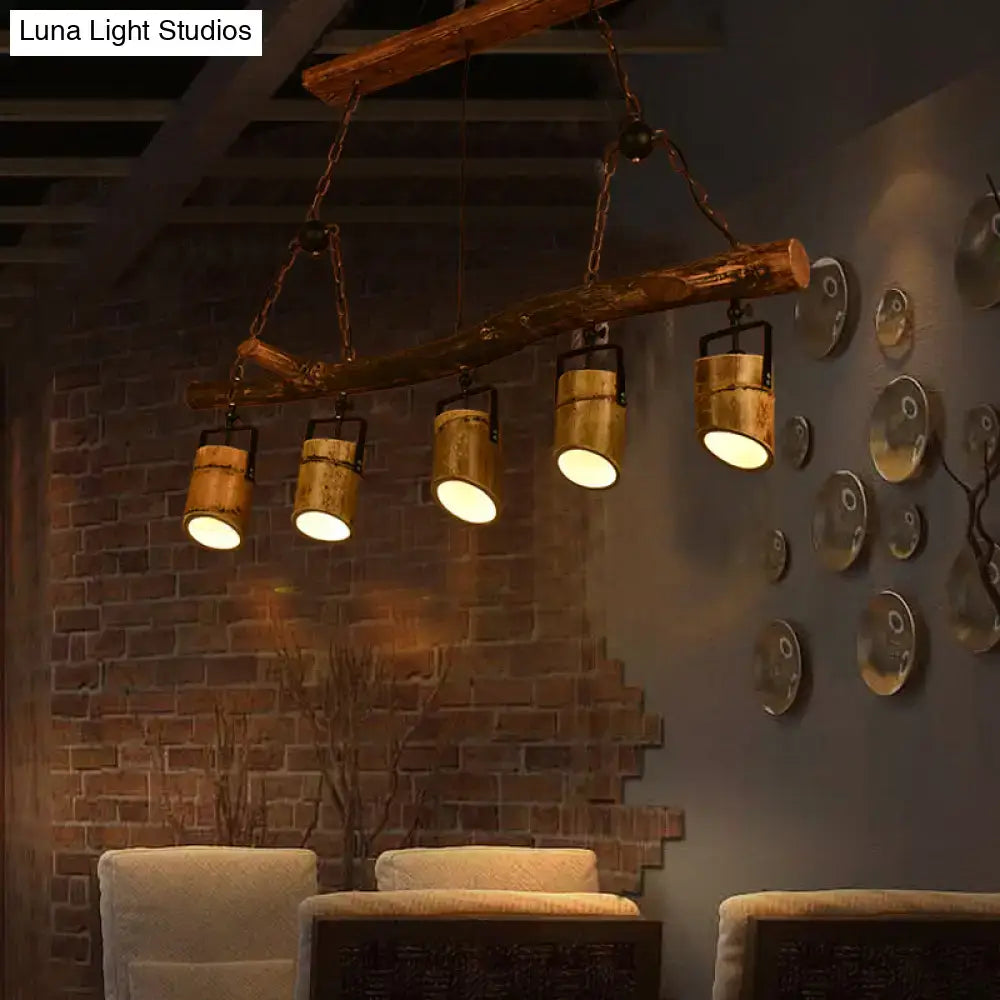 Rustic wood linear island pendant light with five brass finished industrial spotlights for dining room use