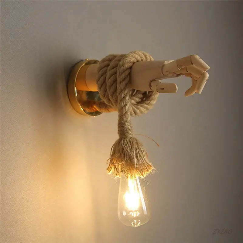 Rustic wooden hand shape hemp rope wall light with articulated joints and exposed filament bulb for restaurant corridor