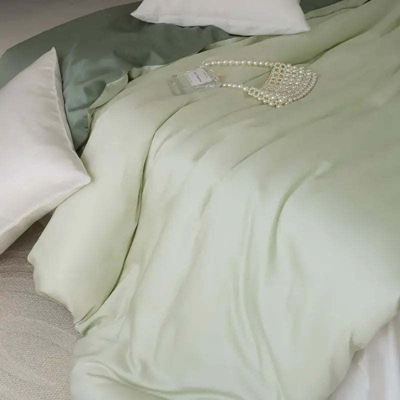 A delicate pearl-embellished handbag rests elegantly on a sage green double layer satin queen duvet set
