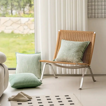 Woven rattan chair with sleek metal frame and sage green plant jacquard pillow covers for living room decorbites decor