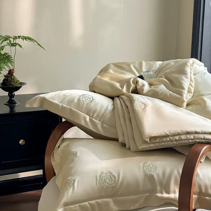 Cream-colored satin quilt set with delicate eucalyptus fiber flower embroidery for elegant bedroom decorbites use