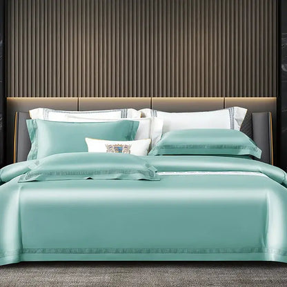 Teal satin duvet cover set with embroidered trim and decorative crest pillow in satin cream and gold egyptian cotton