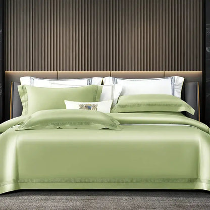 Luxurious sage green satin duvet cover set with elegant beaded trim and embroidered crest pillow sham in cream and gold