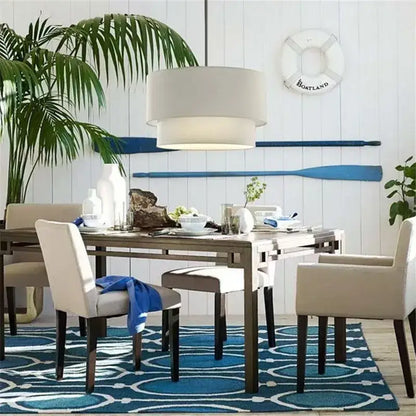 Beige upholstered dining chairs with dark wooden legs under a scandinavian double linen fabric pendant light dining room setup