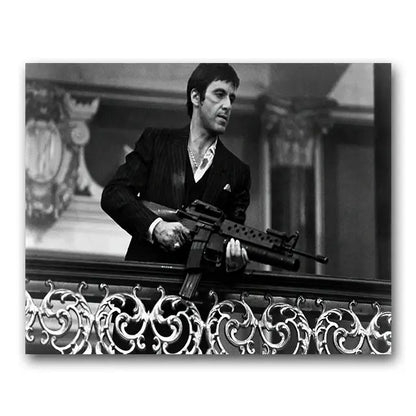 Black-and-white tony montana canvas wall art print of man in pinstripe suit holding assault rifle by ornate railings