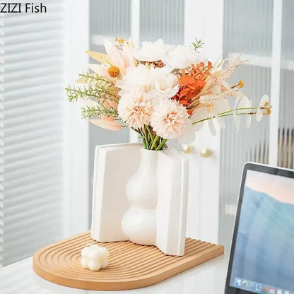 White ceramic vase with modern sculptural design featuring rounded bulbs and angular sides for flowers desk decoration