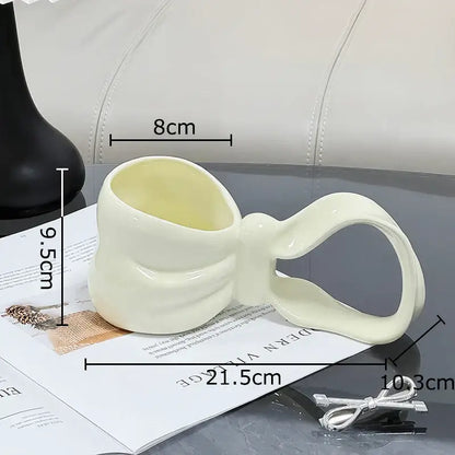 Cream-colored decorbites bowknot ceramic coffee mug with a smooth glossy finish for kitchen tea use