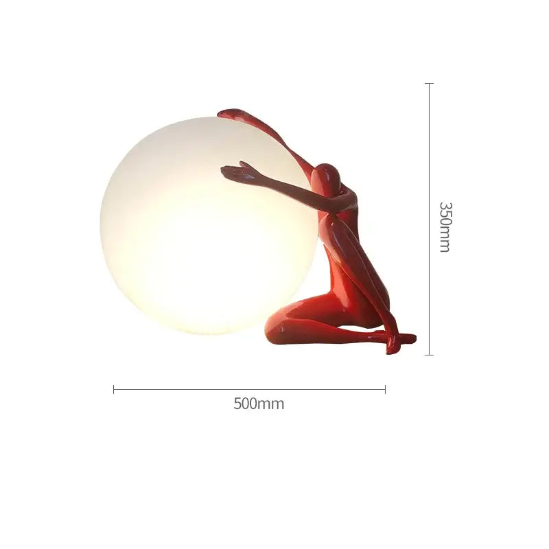 A glossy red glass ball table lamp in a kneeling pose cradling a softly glowing white sphere for decorbites decor