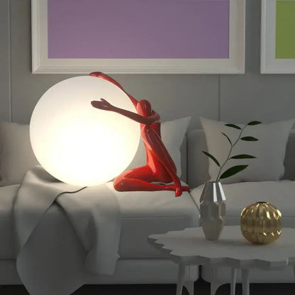 A glossy red sculptural glass ball table lamp cradling a glowing white sphere for bedroom decorbites glass ball decor