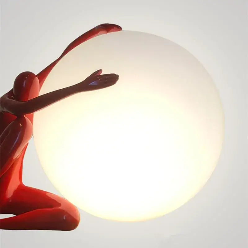 Glossy red sculpted figure cradling softly glowing white glass ball table lamp for bedroom decorbites glass ball decor