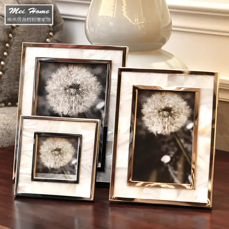 Set of three golden alloy shell photo frames with mother-of-pearl inlays displaying black-and-white dandelion photos