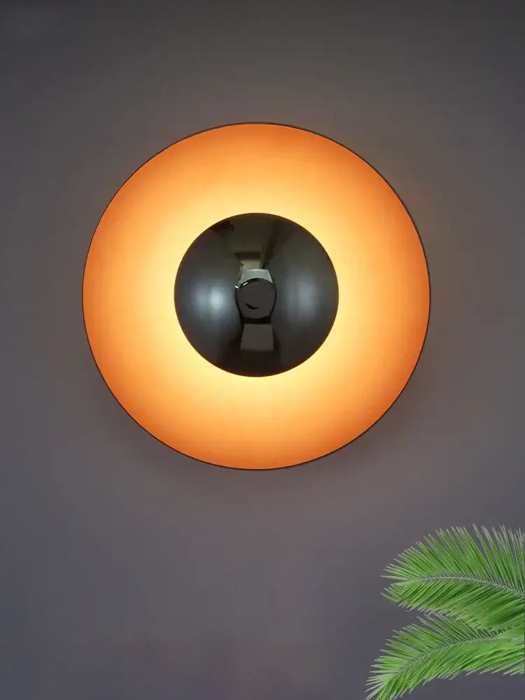 Warm orange decorbites colorful round metal wall lamp with black central fixture ideal for bedroom lighting
