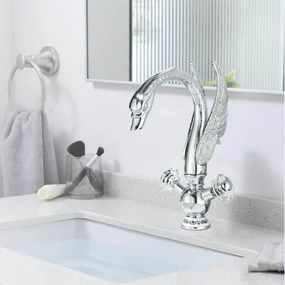 Chrome-finished deck mounted single hole bathroom faucet with swan design, ornate wings, and crystal cold water knobs