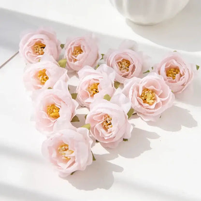 A cluster of delicate pink silk peony flowers with yellow centers and green stems for wedding and home decor